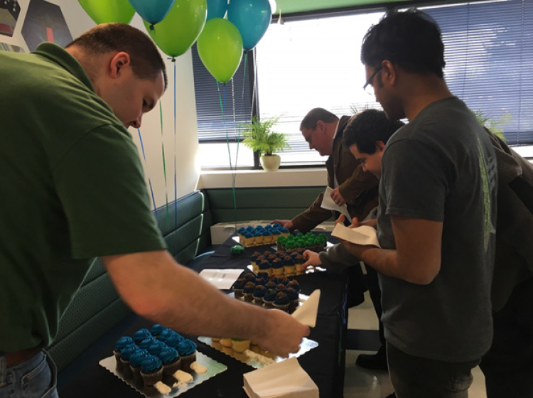 Kitware team members celebrate with cupcakes at company headquarters.