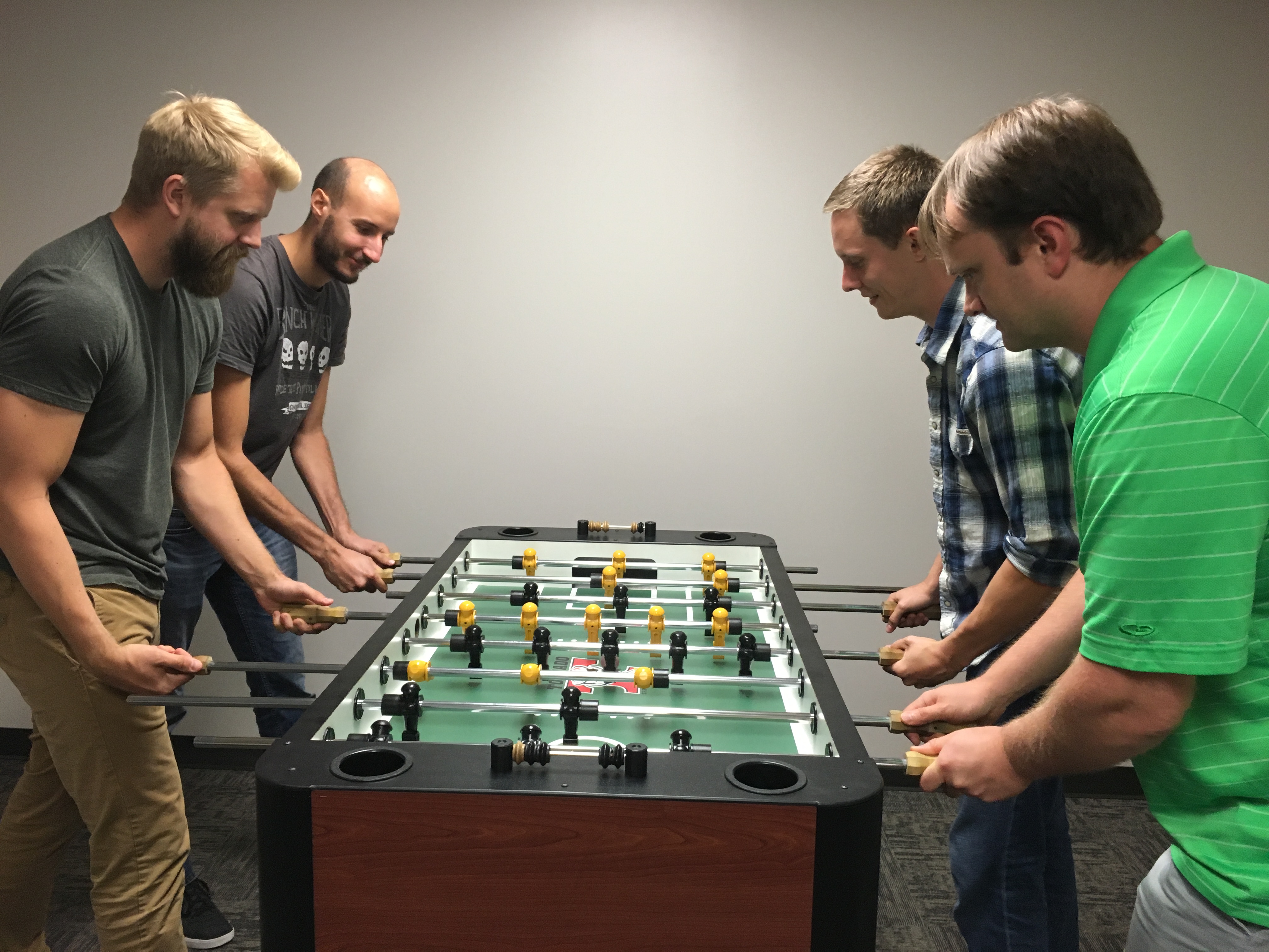 Tim Thirion, Johan Andruejol, Zach Mullen and Cory Quammen play foosball in the Carrboro, North Carolina, office.