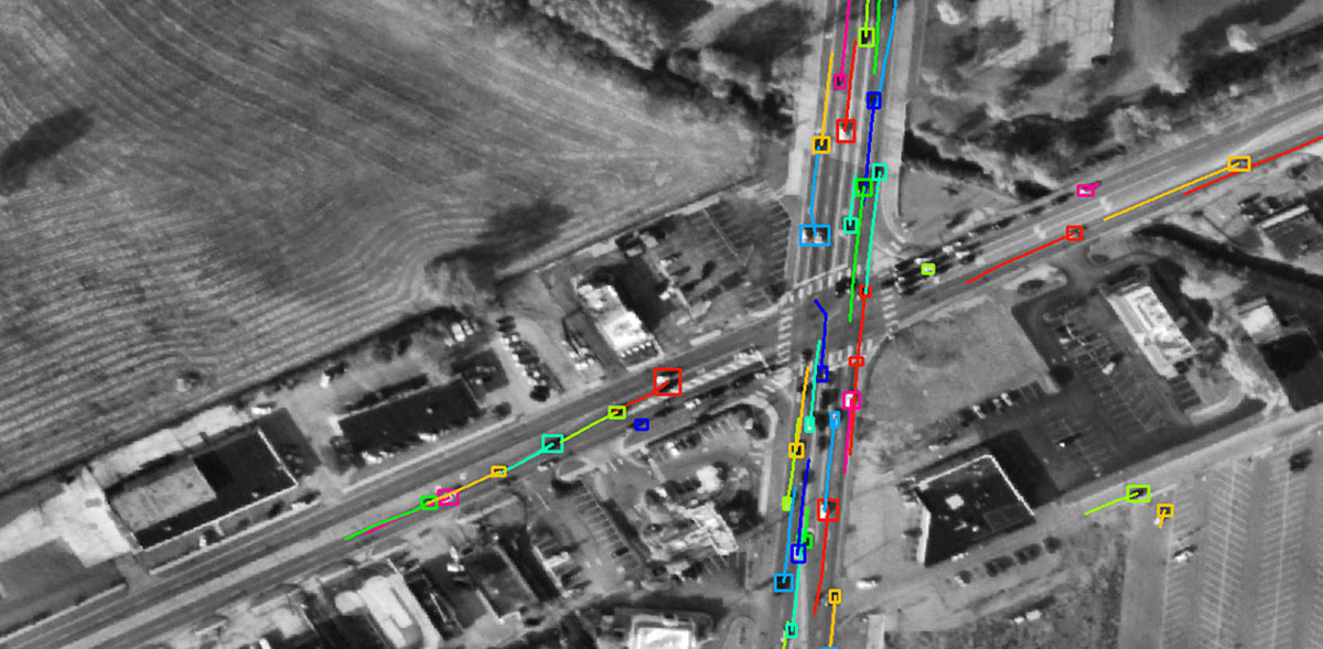 satellite image of a road with cars highlighted.