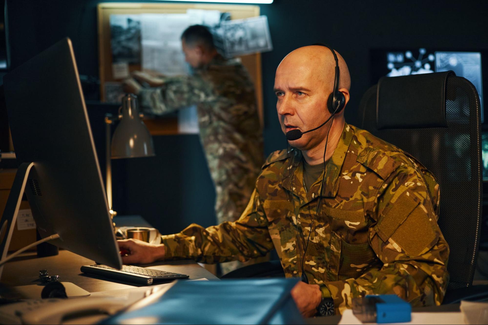Military person looking at computer.