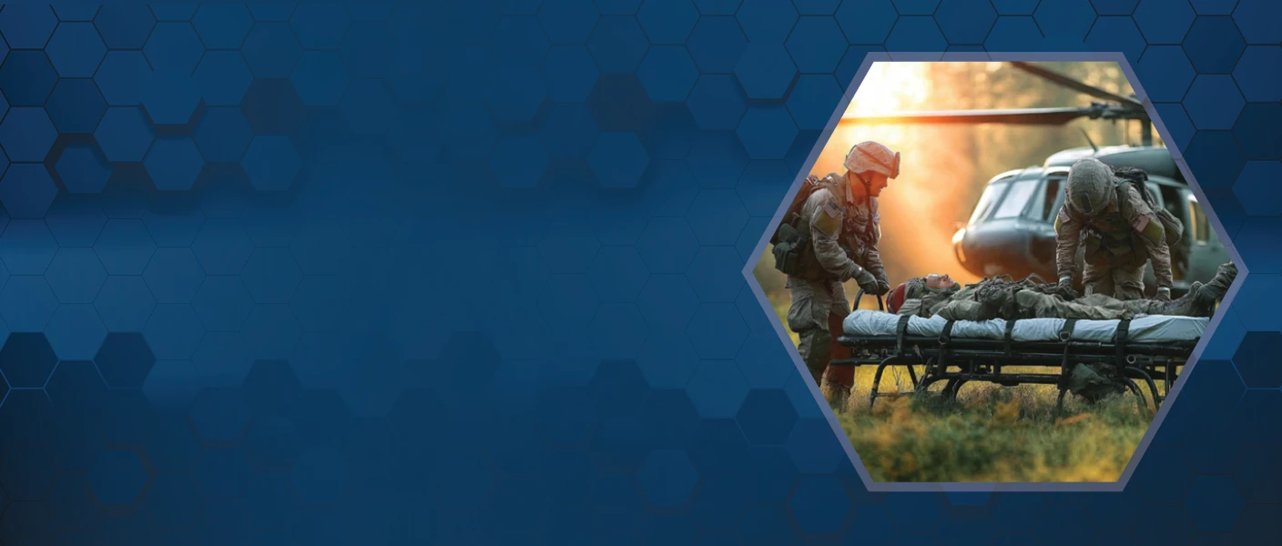 Two military medics tending to an injured soldier on a stretcher in an outdoor field, with a military helicopter in the background, set against a dark blue honeycomb-patterned banner.