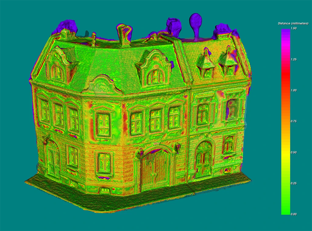 A 3D model comparison render of a detailed European-style building mesh, color-coded by geometric distance error on a scale from 0.00 to 1.50 millimeters.