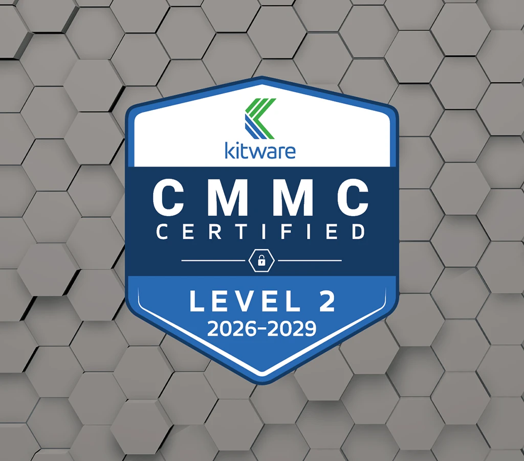 A certification badge for Kitware stating "CMMC CERTIFIED - LEVEL 2 2026–2029" set against a gray 3D hexagonal tile background.